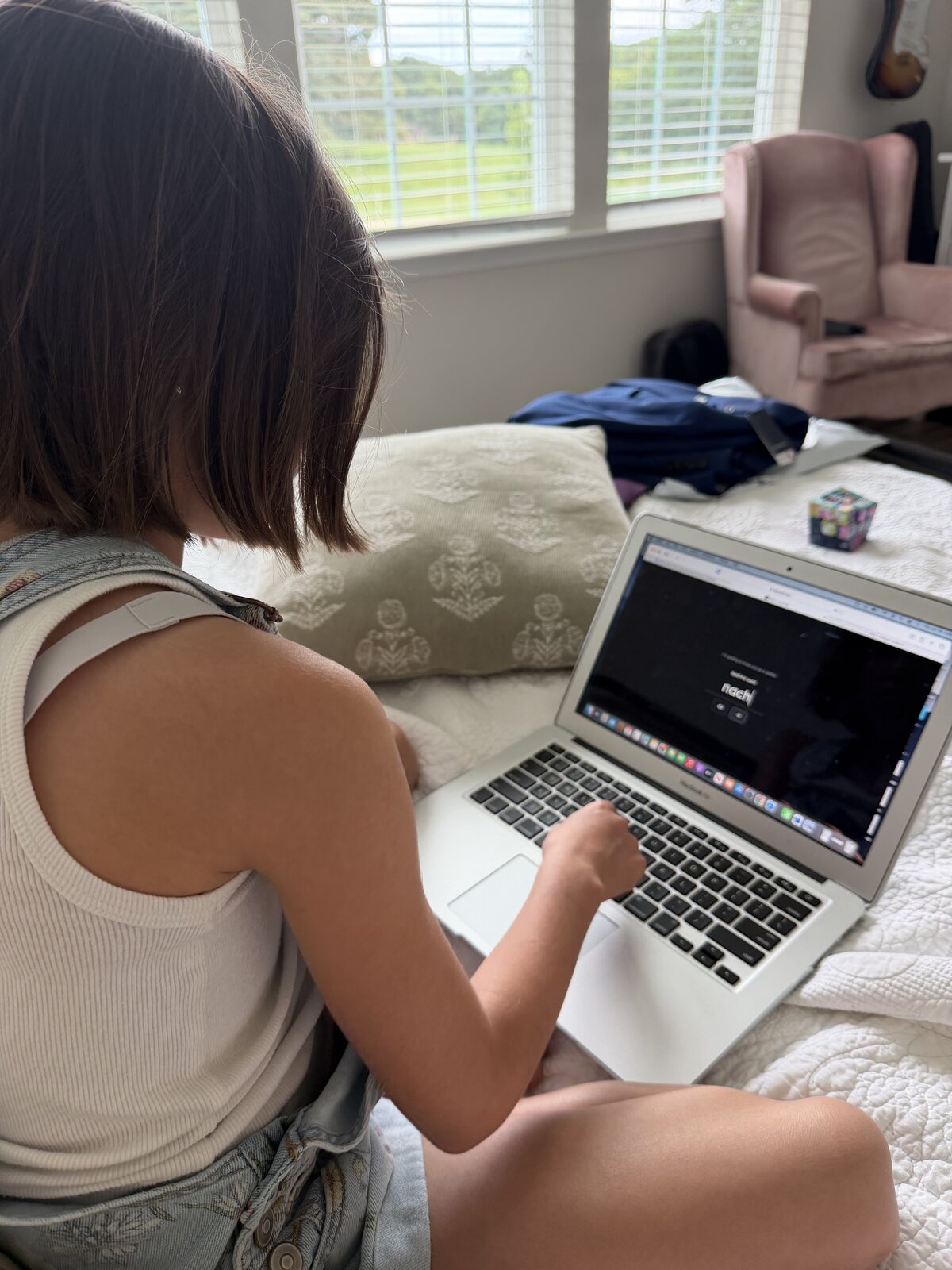 A child practicing spelling with Wyla on a laptop